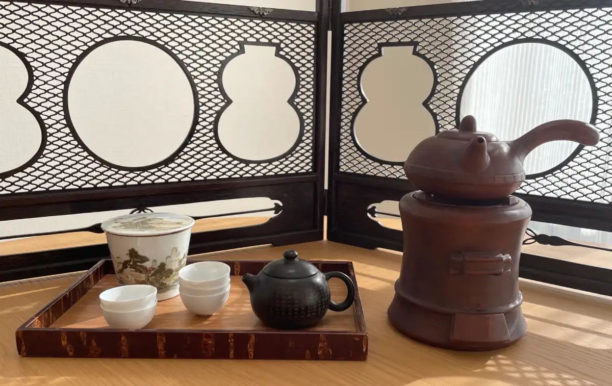 黒泥の急須・涼炉・煎茶盆に汲出、背後に結界（席飾り）を合わせた煎茶席の道具一式
